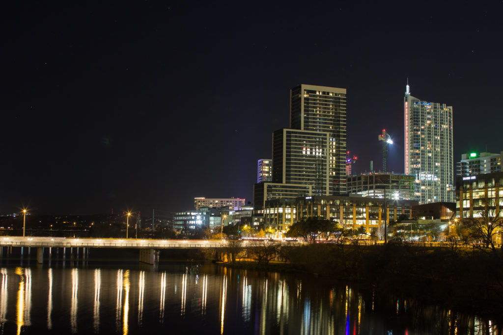 Night view of Austin, Texas downtown with building in the background and water in the foreground